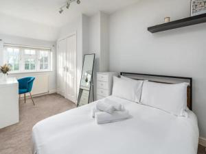 里克曼斯沃斯Pass the Keys Stylish Modern 3 bed house with Parking的一间卧室配有一张白色大床和蓝色椅子