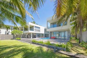 岘港Deluxe Beach Villas by Danatrip的享有棕榈树房屋的外部景色