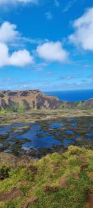 安加罗阿Cute Easter Island Cabana - MaoriTea with free airport transport & Starlink wifi的一座大片的开阔场地,背景是群山