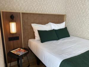 海滨诺德韦克Two Brothers Noordwijk Beach的一间卧室配有带白色床单和绿色枕头的床。