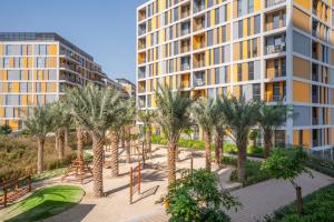 迪拜Tamm - Mesk 1 Tower的公寓大楼拥有棕榈树和游乐场