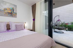 杜布罗夫尼克Lupo Gravosa FREE PARKING的一间卧室配有一张带紫色枕头的床和一个阳台