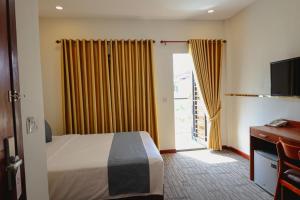 金边Nimith Hotel & Restaurant的酒店客房,设有床和滑动玻璃门