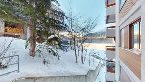 圣莫里茨Abitaziun Residence 10A - St Moritz的地面上积雪的建筑的阳台
