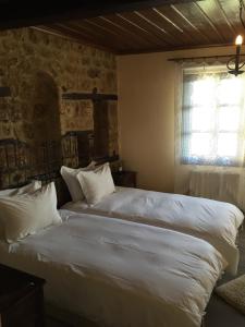 埃泽萨维奥西四季酒店的一间卧室设有两张带白色床单的床和窗户。