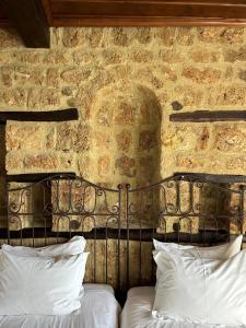 埃泽萨维奥西四季酒店的配有白色枕头的石墙