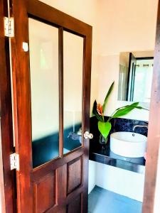 西塔努Mangrove beach house Sri Thanu的一间带水槽和门的浴室