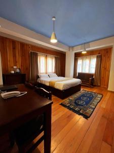 廷布Norbu Healing Hotel的一间卧室配有一张床、一张桌子和一张桌子