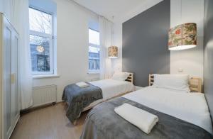 维尔纽斯Halės Guest House - Lollo Luxury的带2扇窗户的小客房内的2张床