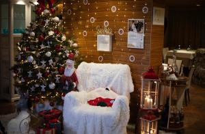 Montereale ValcellinaCasa Valcellina Hotel Ristorante的圣诞客房,配有雪人椅和圣诞树
