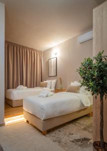 雅典Numa Suites & Lofts Athens的一间卧室设有两张床和盆栽植物