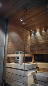 列维LuxLapland Cranberry Levi的一间设有木墙和玻璃墙的桑拿浴室