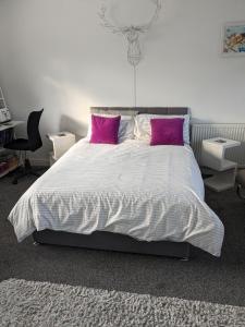 HawardenHawarden near Chester的卧室配有一张带粉红色枕头的大床