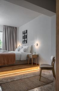 雅典Numa Suites & Lofts Athens的卧室配有1张床、1张桌子和1把椅子