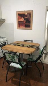 Gualeguaychúdepartamento gualeguaychu的厨房配有一张桌子和椅子,并装饰有绘画作品