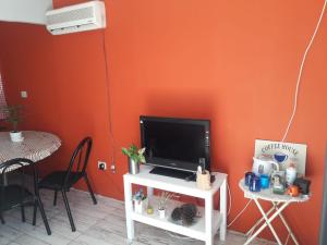 GualeguaychúLa Delia的橙色墙壁的房间的立面上配有电视