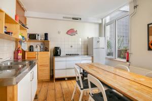 斯希丹Tourist Travel Inn的厨房配有木桌和冰箱。