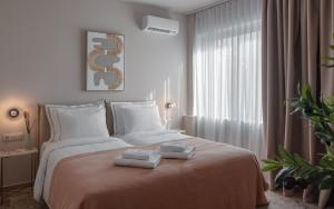 雅典Numa Suites & Lofts Athens的一间卧室配有一张床,上面有两条毛巾