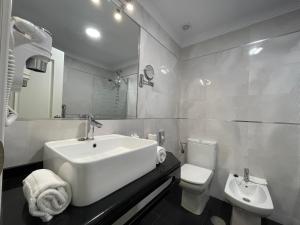 内尔哈卡瓦纳广场酒店的白色的浴室设有水槽和卫生间。
