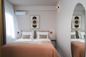 雅典Numa Suites & Lofts Athens的一间卧室配有两张床和镜子