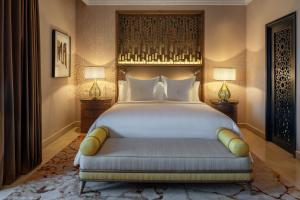 马拉喀什马拉喀什四季酒店的一间卧室配有一张大床和两盏灯