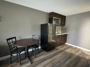 WaynesburgResidency Inn & Studios的厨房配有桌子和不锈钢冰箱。