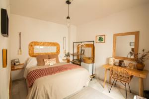 格拉纳达Rooms Vita的一间卧室配有一张床、一张书桌和一面镜子
