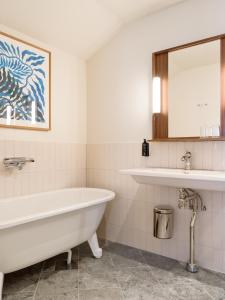 哈尔姆斯塔德Elite Hotel Mårtenson的白色的浴室设有浴缸和水槽。