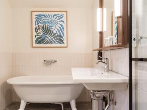 哈尔姆斯塔德Elite Hotel Mårtenson的浴室配有水槽和白色浴缸。