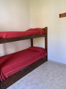 科隆Complejo Rincon del Uruguai的客房设有2张双层床和红色床单