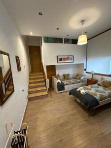 蒙达卡Mundaka Home的一间卧室配有床、沙发和楼梯。