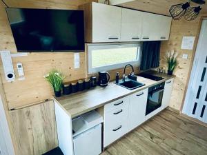GrabceTiny House Village (850m od Suntago)的一个带水槽的厨房和大篷车内的电视