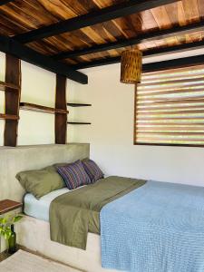 El PlantelAgora at Playa Maderas - Surf House, Cabanas and Casitas的一张位于带窗户的房间的床