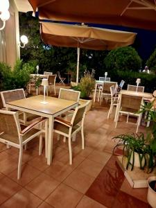 里米尼罗萨蒂酒店的一个带桌椅和遮阳伞的庭院