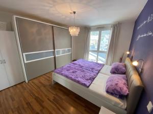 于伯林根Schillerstraße的一间卧室设有紫色的床和窗户