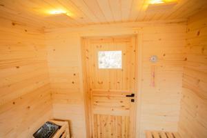 佐尔尼耶戈迪MY TIME Holiday House with sauna的小木屋内带门的木制房间