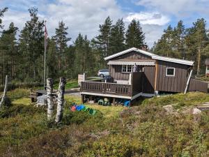 康斯博Turibu - cabin in a nice hiking and skiing area的树林中的小屋,旁边设有停车场