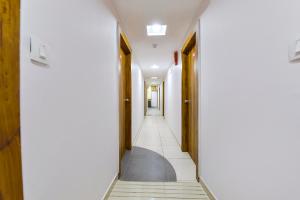 艾哈迈达巴德FabHotel Star的走廊上设有白色的墙壁和木门