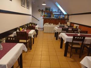 劳耶克特普利采拉吉旅馆的一间配备有白色桌椅和桌子的用餐室