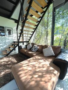 Ban Thap NangPeaceful & Contemporary Duplex Escape的客厅设有一张皮沙发,位于大窗户前