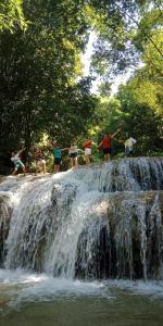 清化Pù luông homestay Ngọc Dậu的一群站在瀑布顶的人