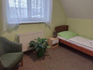 劳耶克特普利采拉吉旅馆的一间卧室配有床、椅子和植物