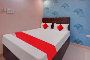 GulzārbāghSuper OYO Flagship Hotel Relax Rainbow的一间卧室配有红色和白色枕头的床