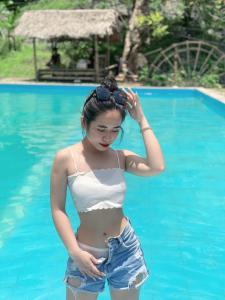 清化Pù luông homestay Ngọc Dậu的站在游泳池里的年轻女子