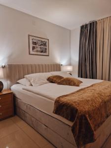 布莱德Aparthotel Gaja的一间卧室配有一张带棕色毯子的大床