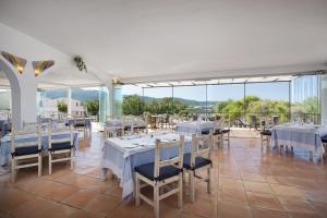 巴哈撒丁岛白鹭酒店的餐厅设有白色的桌椅和大窗户。
