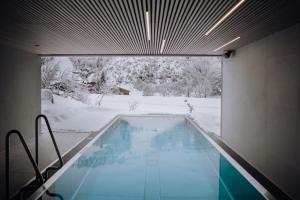 萨尔巴赫Haus Jausern的地面上积雪的房子里的一个游泳池