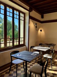 Saint-AngelLe Manoir du Rigouneix au coeur de la nature, calme-sauna-dîner maison的带窗户的客房内配有2张桌子和椅子