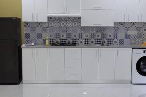 FeydhooVeyodhoshuge, S.Feydhoo, Addu city的厨房配有白色橱柜和黑色冰箱。