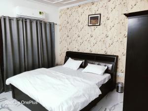 勒克瑙Osho homes的卧室内的一张带黑色窗帘的床